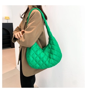 Borsa a mezzaluna verde trapuntata indossata con cappotto marrone per look invernale