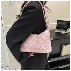 Detailed view of a pink quilted nylon shoulder bag with dreamlike butterfly and cloud prints