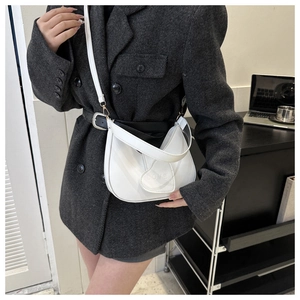 Close-up of white heart-shaped leather hobo bag on model in a minimalist office setting