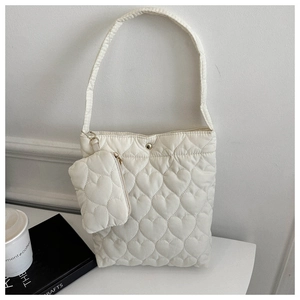 Vue détaillée du motif matelassé en cœur et du bouton pression du sac seau blanc