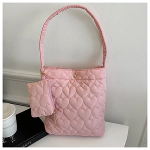 Détail du sac seau rose matelassé avec motif cœur et petit porte-monnaie assorti