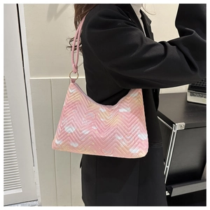 Detail of pink quilted nylon bag featuring colorful butterfly and cloud gradient patterns