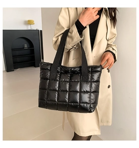 Detail of black quilted puffer tote bag in glossy nylon with chic checkered pattern