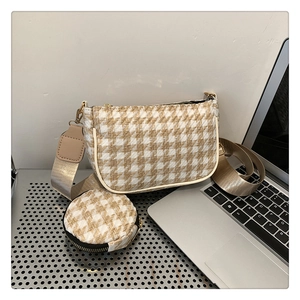 Detail of houndstooth weave underarm bag with matching round coin purse and wide strap