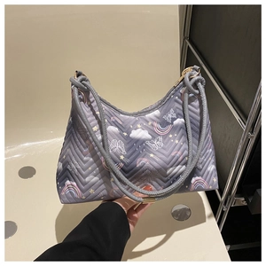 Detail of grey quilted nylon tote bag featuring colorful rainbow and butterfly patterns