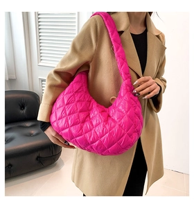 Dettaglio della borsa a tracolla trapuntata rosso rosa con cuciture a rombi e trama in nylon