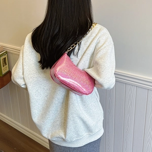 Borsa sottobraccio rosa glitterata con spessa catena dorata portata a spalla