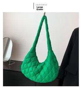 Detail of a large quilted vibrant green puffer shoulder bag with a rhombic stitching design
