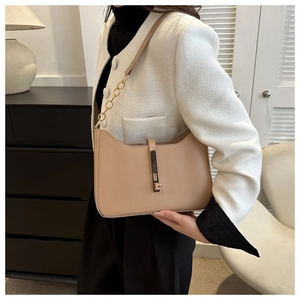 Detail of khaki leather underarm bag with gold metal buckle and elegant chain strap