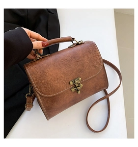 Close-up of vintage brown embossed leather texture and antique metal twist lock detail
