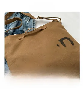 Détail d'un sac cabas en toile marron avec imprimé MOOD noir et bandoulière réglable