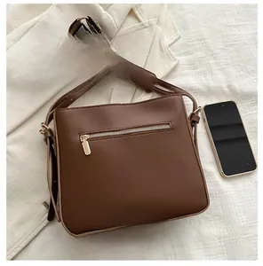 Borsa a tracolla marrone in ecopelle con tasca a zip e tracolla larga decorata