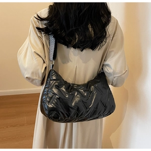 Vue de dos du sac matelassé noir avec bandoulière rayée porté par un mannequin