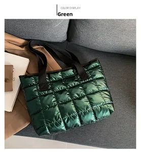 Detail of green quilted tote bag with metallic finish on a cozy sofa setting