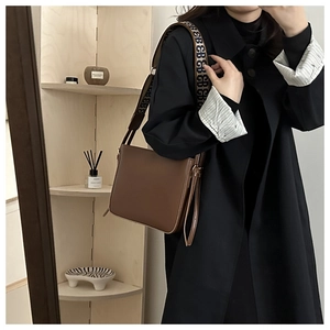 Borsa a tracolla in pelle marrone con tracolla in tessuto logo e cappotto nero