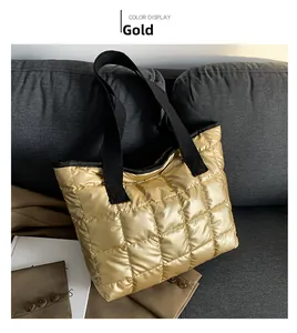 Close-up of golden quilted tote bag with lattice texture and black fabric strap