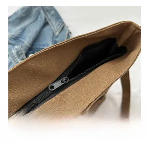 Vue détaillée de la fermeture à glissière en métal sur le sac fourre-tout en toile brune