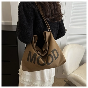 Sac cabas marron en toile avec inscription MOOD dans un décor intérieur élégant