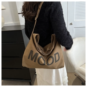 Détail du sac fourre-tout en toile marron avec imprimé MOOD et sangle réglable