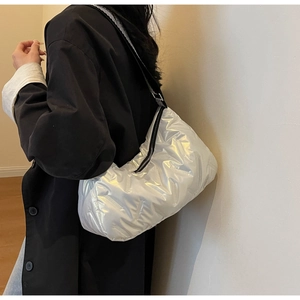 Détail du sac matelassé argenté métallisé avec bandoulière rayée et fermeture éclair