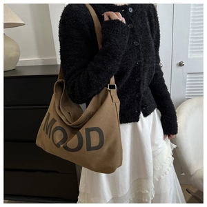 Détail d'un sac cabas en toile marron avec imprimé 'MOOD' noir et large bandoulière