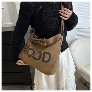 Détail de l'imprimé 'MOOD' sur un grand sac cabas en toile marron avec large bandoulière