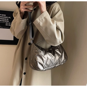 Détail du sac hobo matelassé argenté avec une large bandoulière géométrique