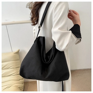 Détail de la bandoulière réglable avec boucle dorée sur un grand sac cabas en toile noir
