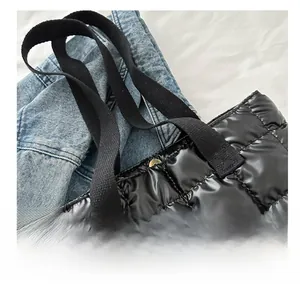 Detail of black quilted tote bag showing high-quality metallic snap button and strap