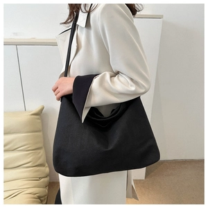 Détail d'un grand sac fourre-tout en toile noire montrant le tissu épais et résistant