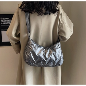 Gros plan du sac matelassé argenté brillant avec bandoulière tissée aux motifs géométriques