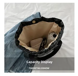 Detail showing the large interior capacity of the black quilted puffer tote bag