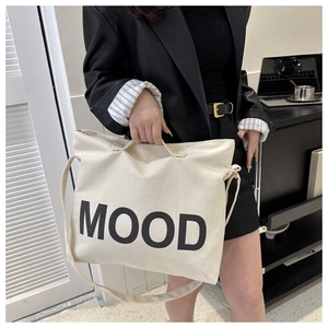 Détail du sac fourre-tout en toile blanc cassé avec imprimé MOOD et bandoulière réglable