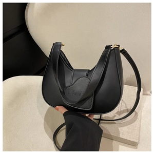 Détail du sac hobo noir avec rabat en forme de cœur et inscription LOVE embossée
