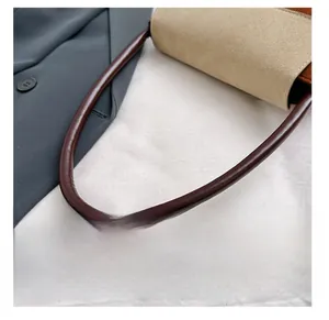 Detail view of the brown leather handle and premium khaki suede material of the bag