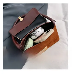 Interior view showing the large capacity and gold square lock of the suede shoulder bag