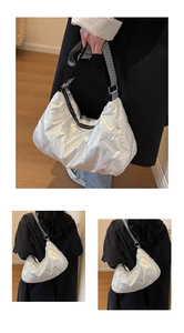 Gros plan du sac matelassé argenté métallisé avec bandoulière rayée noire et blanche