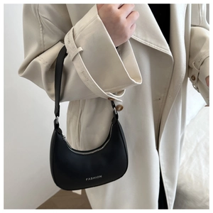 Close-up of black leather crescent underarm bag with white FASHION text detail