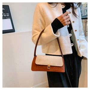 Close-up of the vintage contrast color underarm bag with gold lock and suede detail