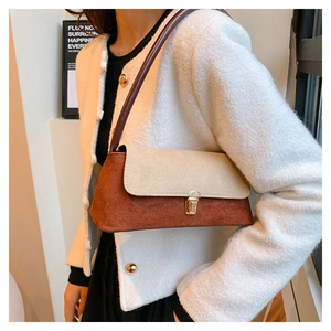 Detail of contrast color shoulder bag with gold metal buckle and matte suede finish