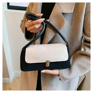 Detail of contrast shoulder bag featuring suede texture and a golden metal clasp lock