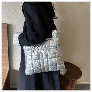 Close-up of quilted silver padded tote bag with metallic finish and soft down-like texture