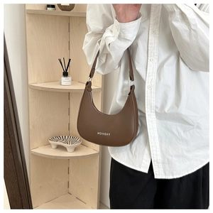 Brown leather crescent hobo bag with silver zipper and fashion typography detail