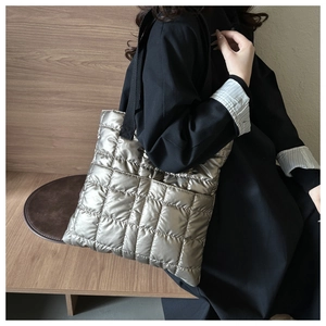 Close-up of metallic silver quilted tote bag showing large puffy stitch patterns