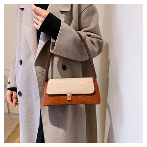 Detail of vintage bi-color shoulder bag with red-brown suede and metallic clasp closure