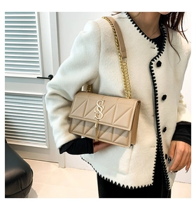 Quilted beige shoulder bag featuring golden chain strap and elegant tassel detail
