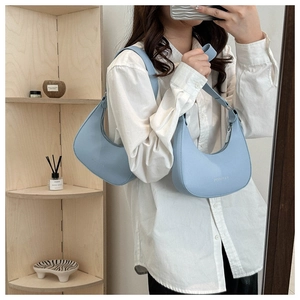 Detail of light blue leather hobo shoulder bag with fashion lettering and silver zipper