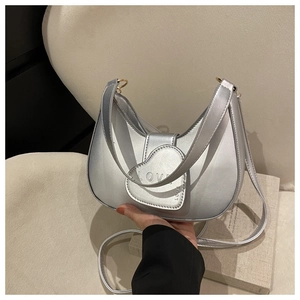 Détail du sac demi-lune argenté avec boucle cœur et bandoulière ajustable