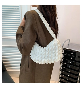 Detail of white bubble texture fabric on a stylish ruched underarm shoulder bag