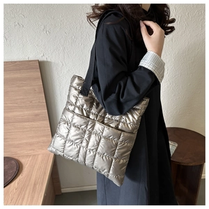 Detailed close-up of champagne gold quilted tote bag with metallic gloss and texture